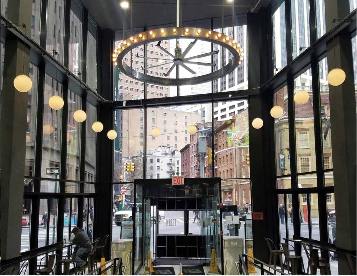 Double-height glass entry with steel mullions and a ring chandelier, Essen.