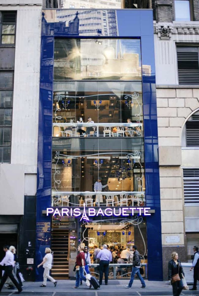 Multi-story glass storefront framed in cobalt blue, Paris Baguette.